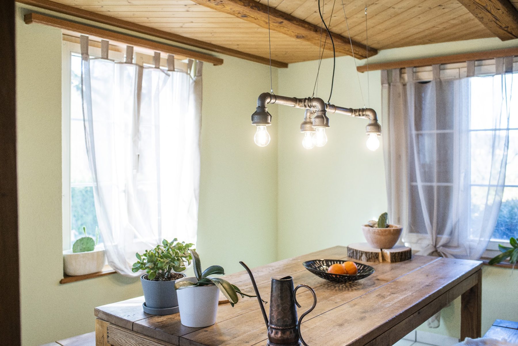 Esszimmer mit frisch gestrichener grüner Wand und Holzdecke
