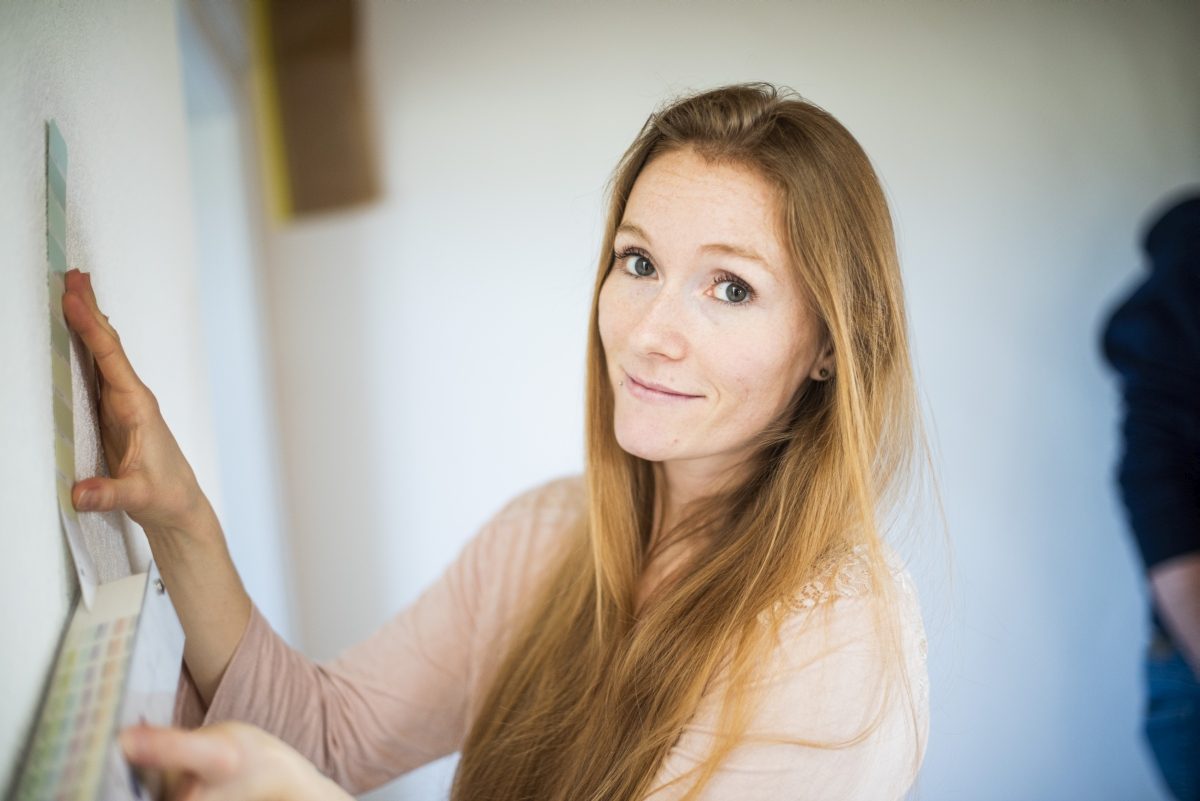 Manuela Driesener hält ein Farbmuster an die Wand