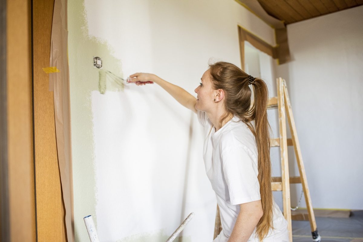 Manuela Driesener streicht eine Wand mit der Farbwalze