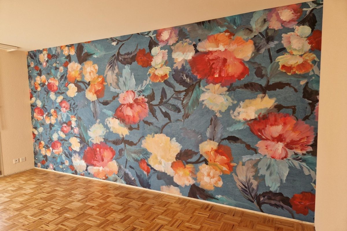 Wand mit grosser Blumentapete auf blauem Grund